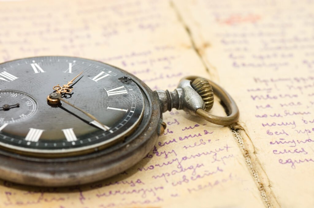 Vintage pocket watch resting on a handwritten notebook page